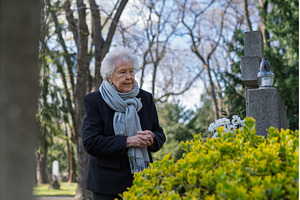 Elderly woman praying at a grave., a Holiday Photo by HalfPoint