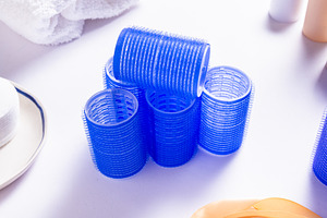Set of Blue Plastic Hair Rollers with Hair Care Products on Whit, a Business Photo by MDBildes