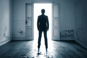 Man standing in dark room looking towards bright open doorway, a Person Photo by DanFLCreativo