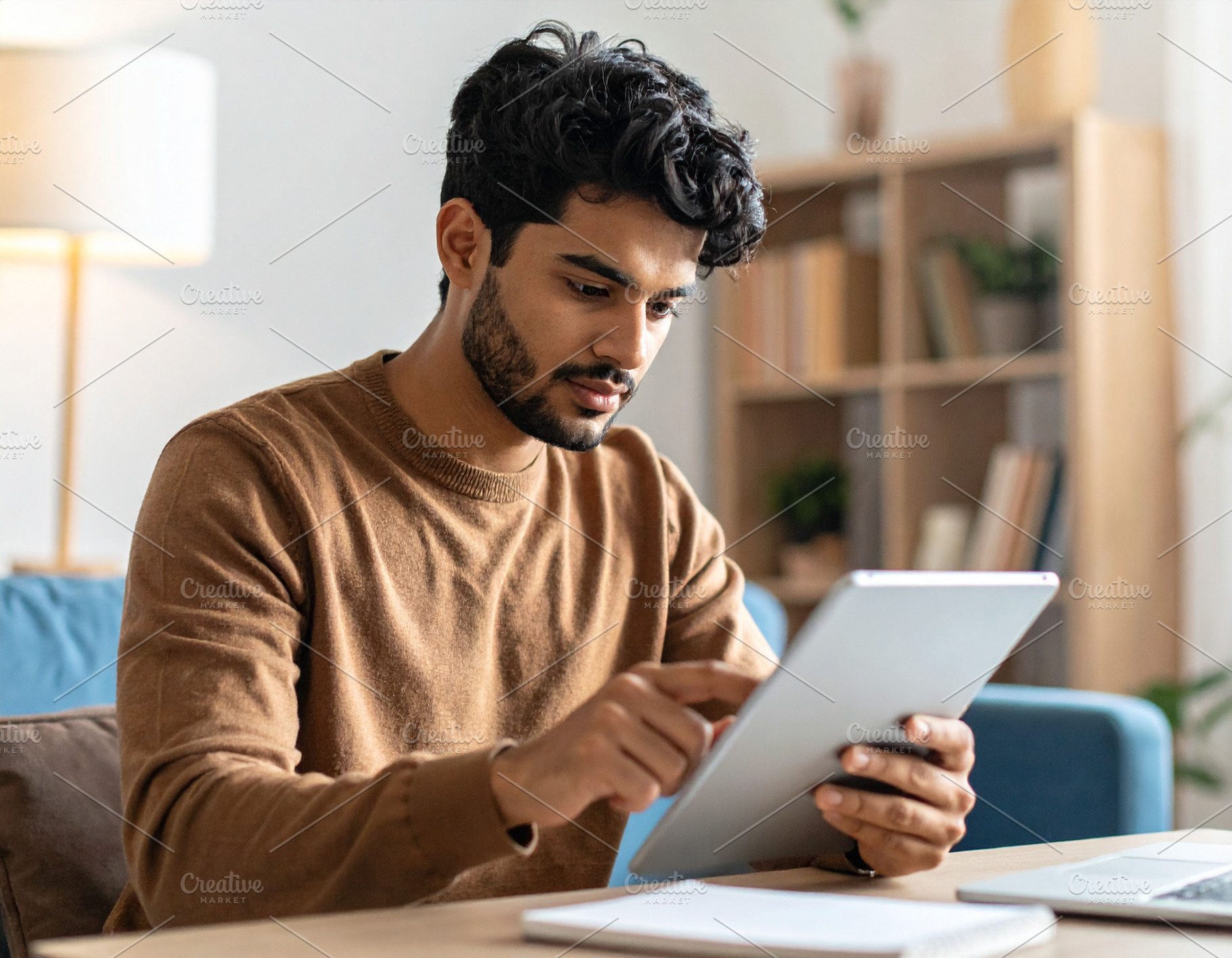 Young adult using a digital tablet to study at home, a School & Education Photo by DanFLCreativo
