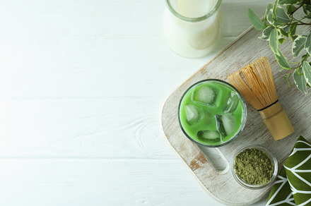 Matcha latte and accessories for making on white wooden table, a Food & Drink Photo by AtlasStudio PRO