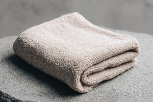 Woven Cotton Towel Folded on Stone, a Beauty & Fashion Photo by Virgo Studio