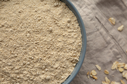 Organic White Oat Flour in a Bowl on a gray background, top view, a Food & Drink Photo by LiudmylaChuhunova