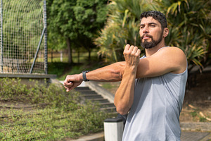 Young athletic man stretching outdoors in a park before workout, a Sports & Recreation Photo by etorres69