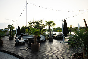 Outdoor seating area with tropical plants and decorative string lights, a Photo by AS photostudio