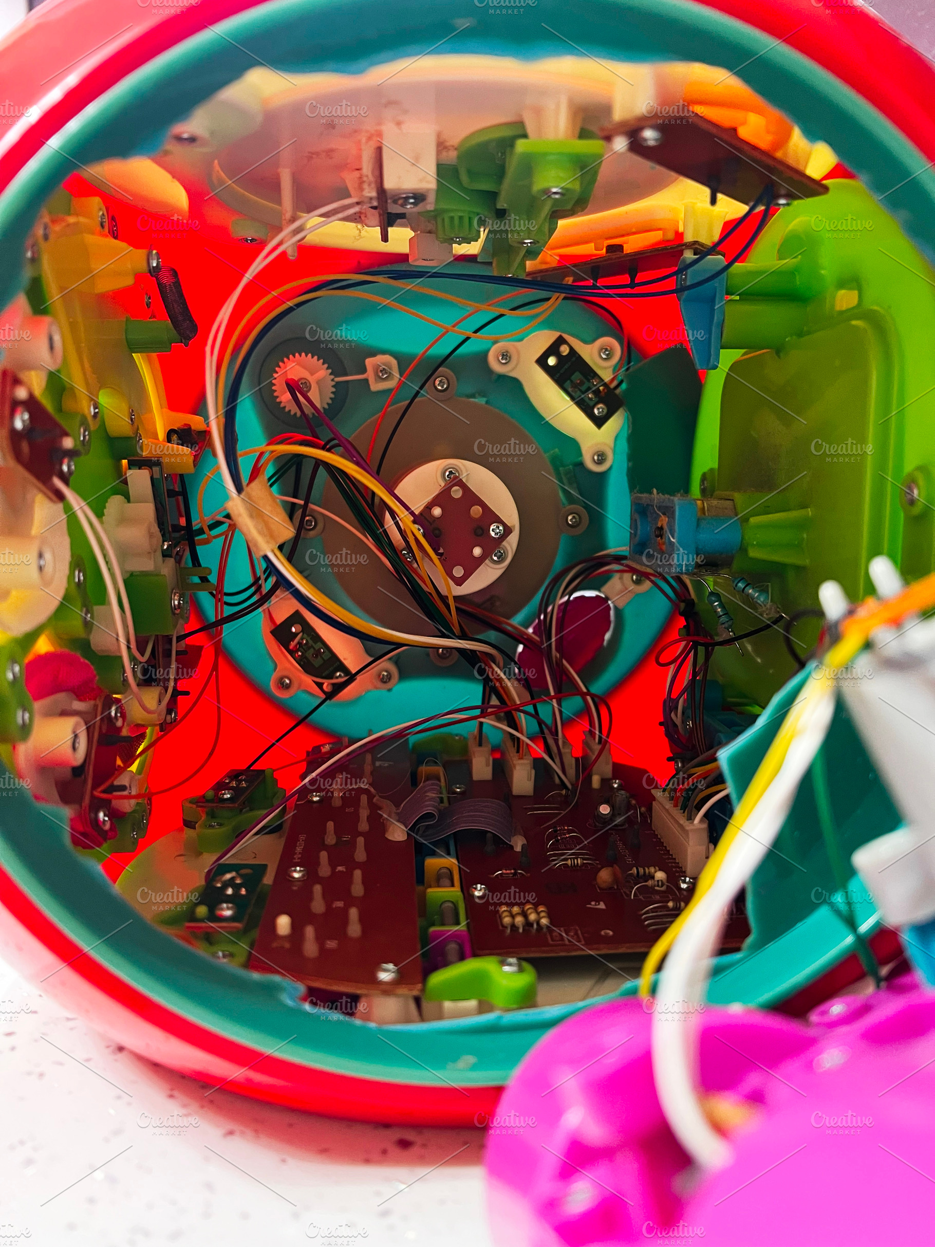 Interior circuits and components of a colorful electronic toy showing intricate, a Photo by AS photostudio