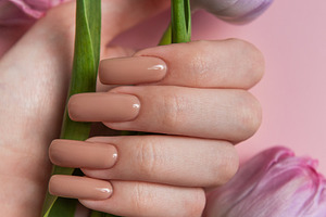 Woman hand with perfect nude manicure holding tulip flowers on p, a Beauty & Fashion Photo by Olena Rudo