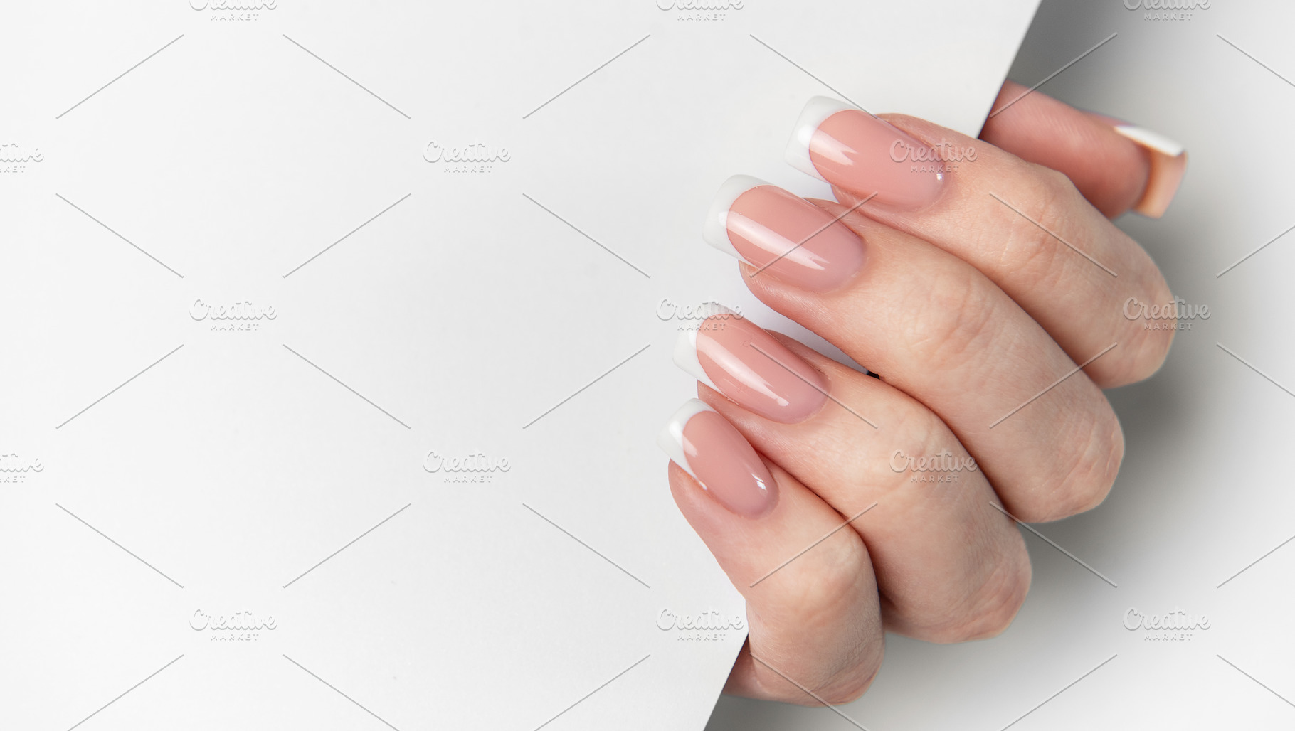 Woman hand showing french manicure on white background, a Beauty & Fashion Photo by Olena Rudo