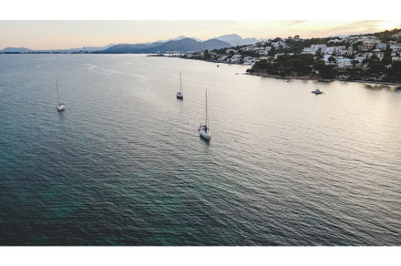 Boats floating on rippling sea under, a Nature Photo by Daniel Megias