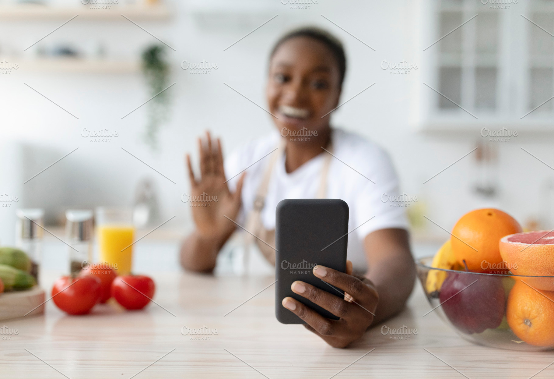 Glad millennial african american woman waving hand, taking photo on phone on ta, a Person Photo by Prostock-Studio