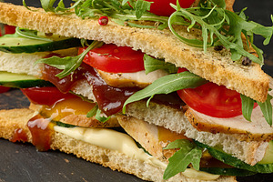 Grilled chicken sandwich with fresh tomatoes, cucumbers, arugula