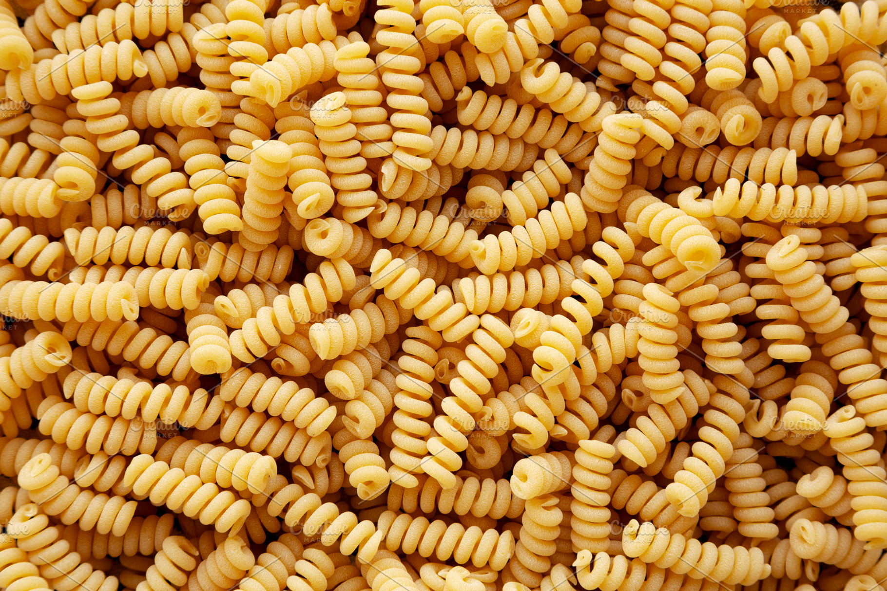 Uncooked Organic Dry Fusilli Pasta, top view. Flat lay, overhead, a Food & Drink Photo by LiudmylaChuhunova