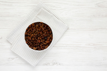 Dried Brown Raisins in a Gray Bowl, top view. Flat lay, overhead, a Food & Drink Photo by LiudmylaChuhunova