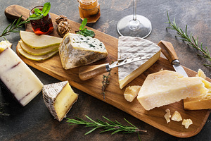 Cheese assortment with nuts and jams on stone board.Top view., a Food & Drink Photo by Volff
