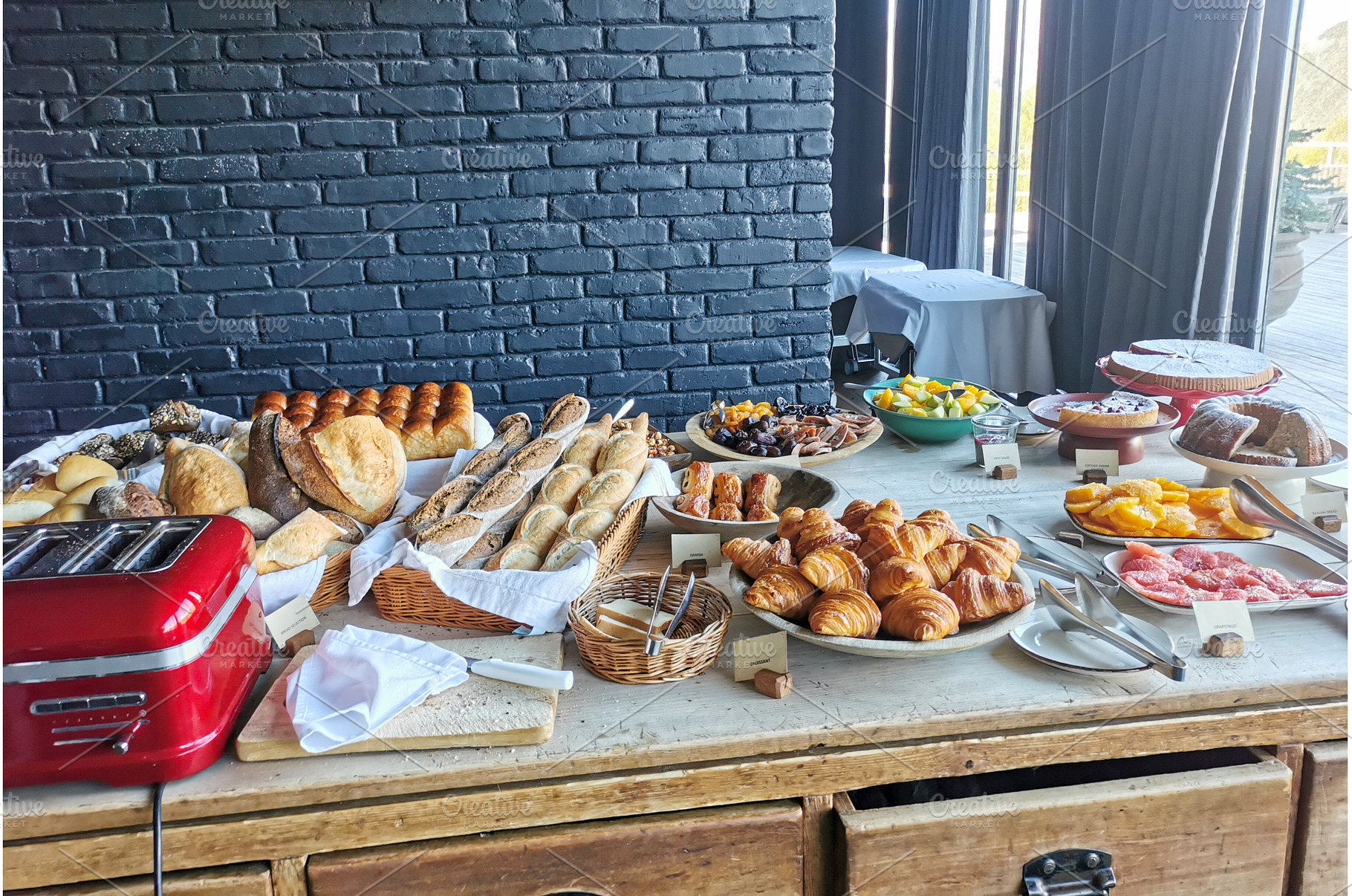 Buffet table with bread, pastries, a Food & Drink Photo by sceptical cactus
