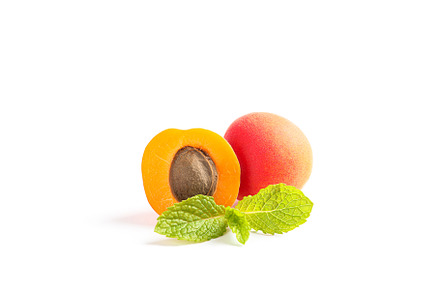 Apricots with mint isolated on white background, a Food & Drink Photo by AtlasStudio