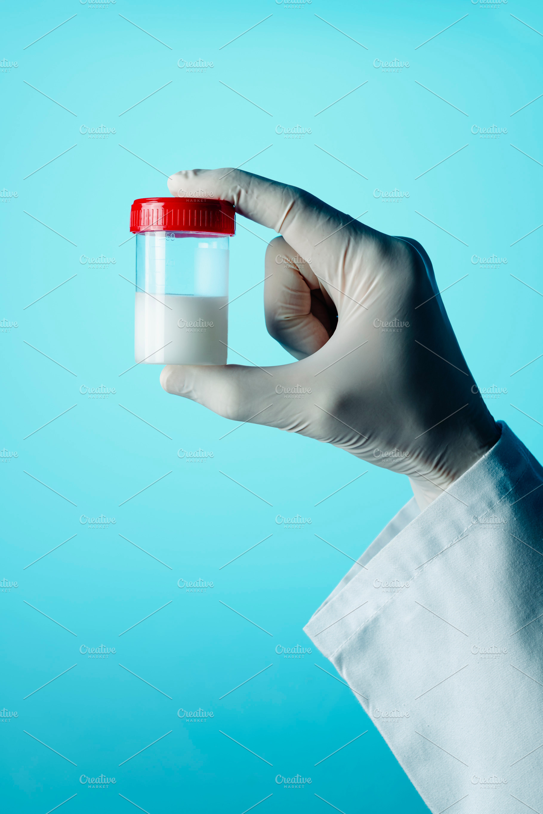 man holds a sterile container with some semen, a Photo by Nito