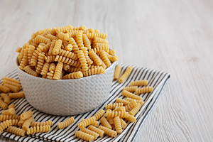 Uncooked Organic Dry Fusilli Pasta in a Bowl, side view. Copy sp, a Food & Drink Photo by LiudmylaChuhunova