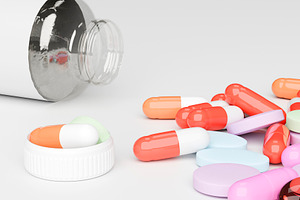 Scattered pills and capsules beside open medicine bottle, a Health & Medical Photo by RF Images