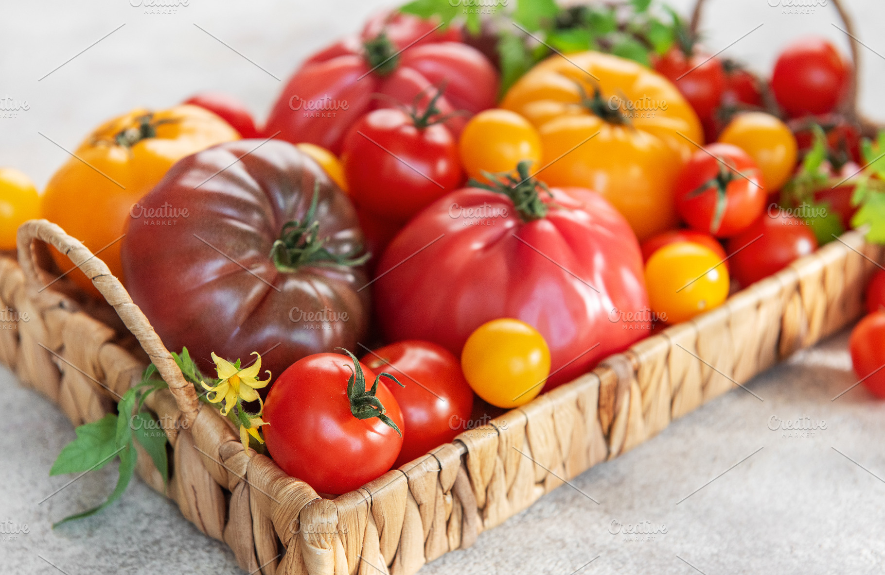 Fresh organic heirloom tomatoes in a woven basket, a Food & Drink Photo by Olena Rudo