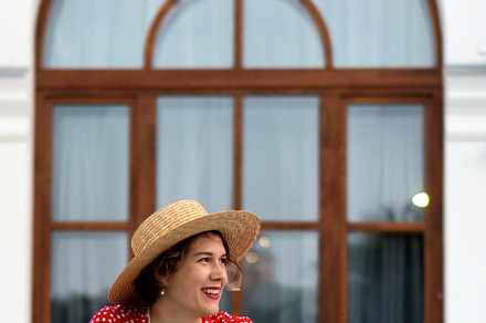 Smiling woman in red dress and hat