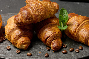 Freshly baked croissants on a black table, delicious breakfast, a Food & Drink Photo by ndanko