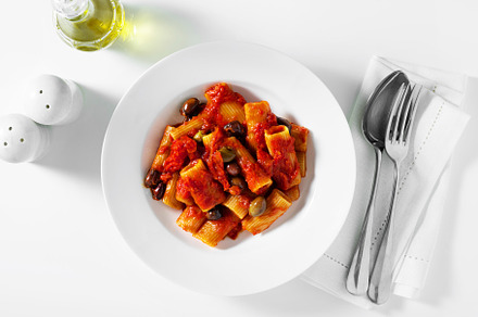 Italian tortiglioni pasta puttanesca with tomato sauce and black