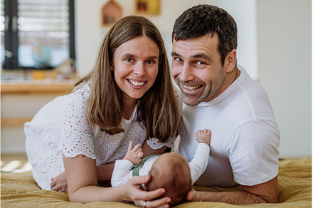 Happy parents cuddling with their, a Person Photo by HalfPoint