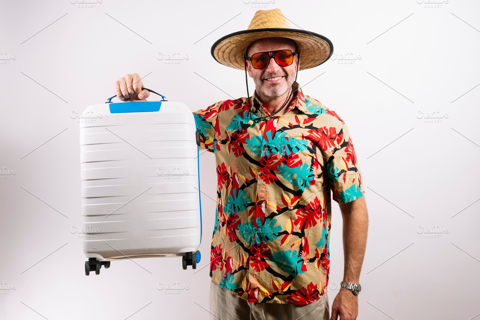 Traveler holding white and blue rolling suitcase, a Holiday Photo by karrastock
