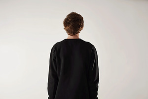 Young man in black sweatshirt on grey background, back view, a Beauty & Fashion Photo by AlyaAnd