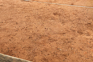 Yellow tennis balls scattered on a clay tennis court, a Photo by AS photostudio