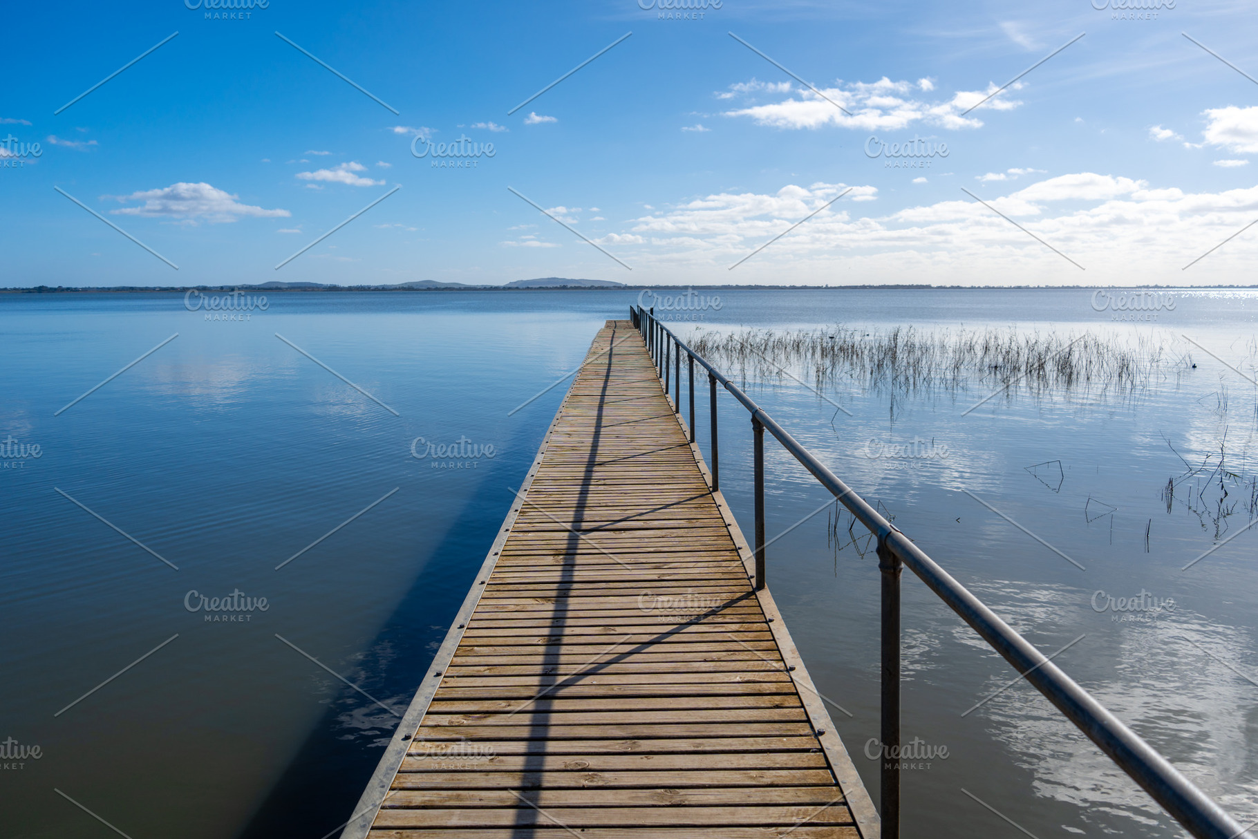 Wooden pier extending over Lake Colac, Victoria, Australia on a, an Architecture Photo by GoodGoods