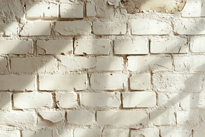 Close-up of a weathered white brick wall with soft shadows, showcasing texture, a Background Photo by ImageMir