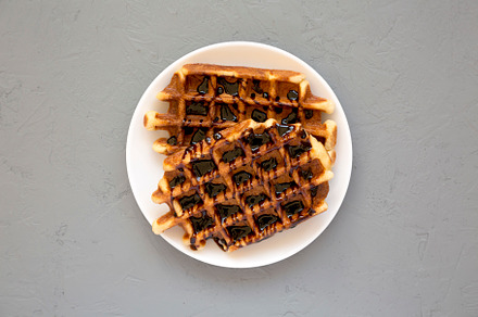 Yummy Homemade Belgian Sugar Waffles on a white plate on a gray, a Food & Drink Photo by LiudmylaChuhunova