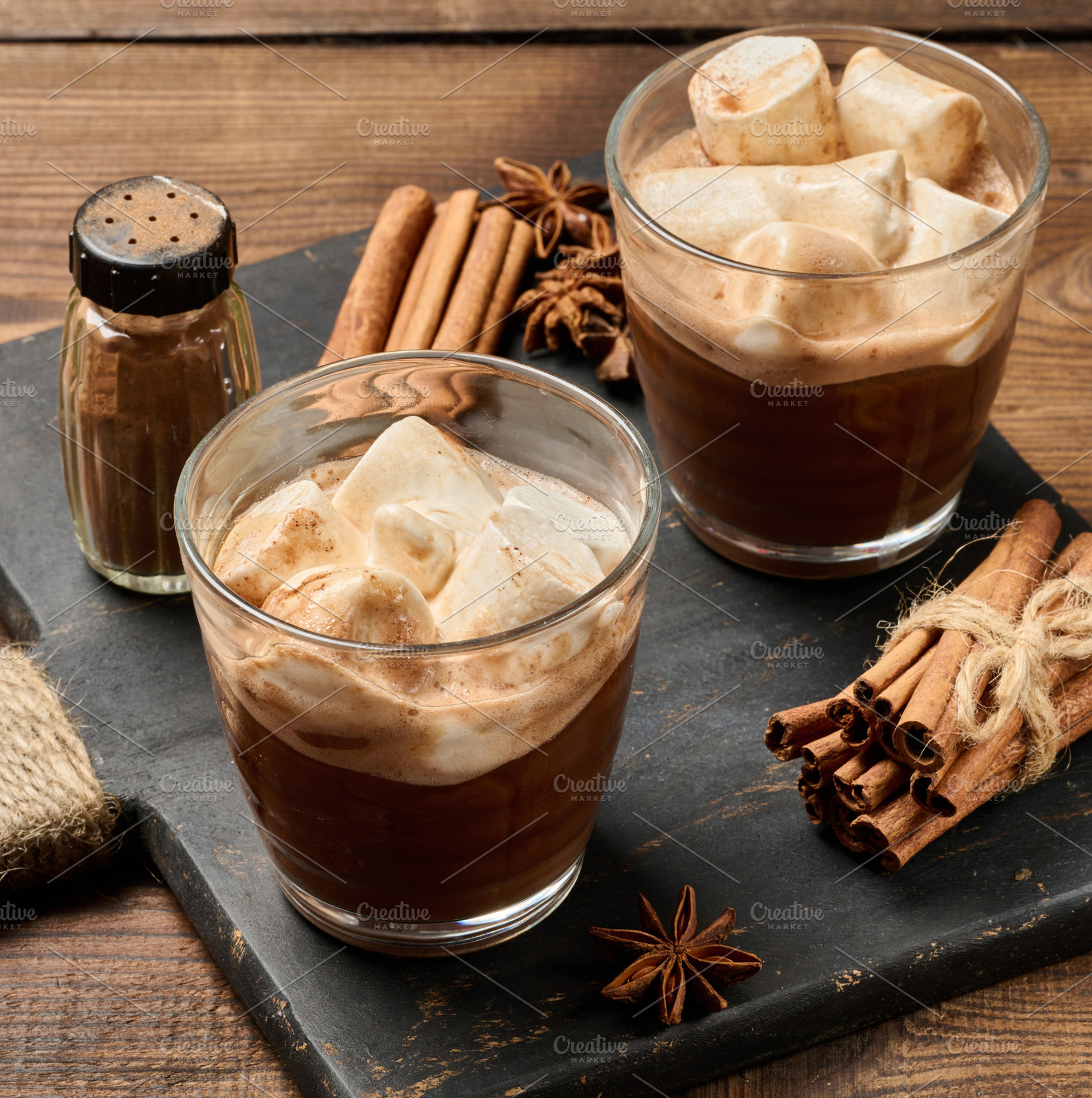 Two glasses of hot chocolate with fluffy marshmallows on a slate, a Food & Drink Photo by ndanko