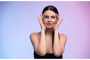 Young woman applying cosmetic eye, a Health & Medical Photo by volodymyrshtun13795