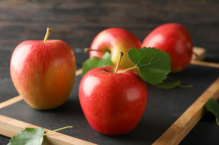Apples and cutting board on wooden background, space for text, a Food & Drink Photo by AtlasStudio
