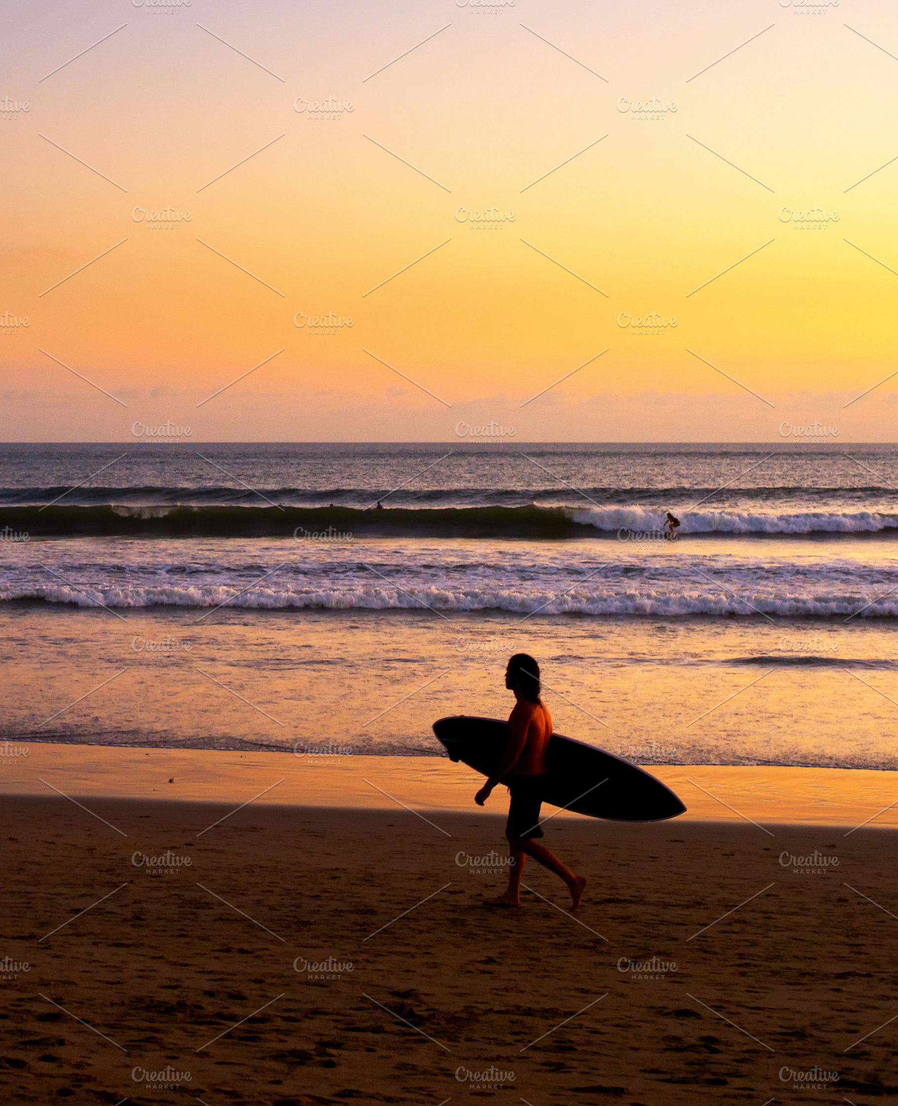 Surfer on beach at sunset containing bali, beach, and surfing, a Person Photo by joyt