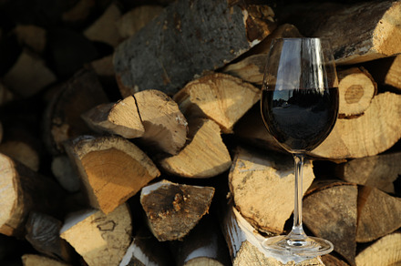 Glass of wine outdoor on folded firewood, a Nature Photo by AtlasStudio PRO