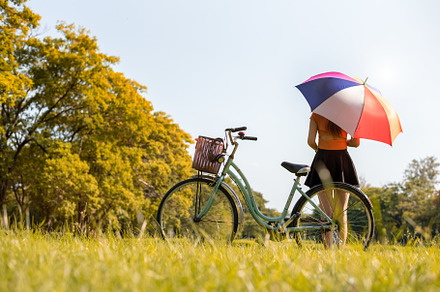 Woman with colrful umbrella and bicycle in park. People and rela, a Person Photo by Ministocker