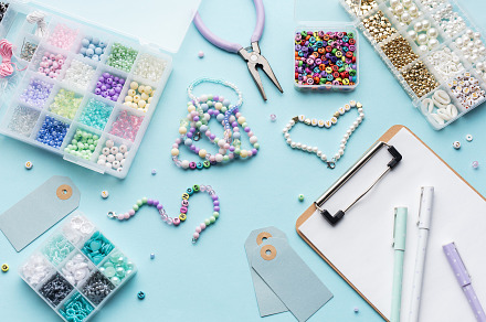 Colorful beads, pliers, clipboard and price tags arranged on blu, an Arts & Entertainment Photo by Olena Rudo