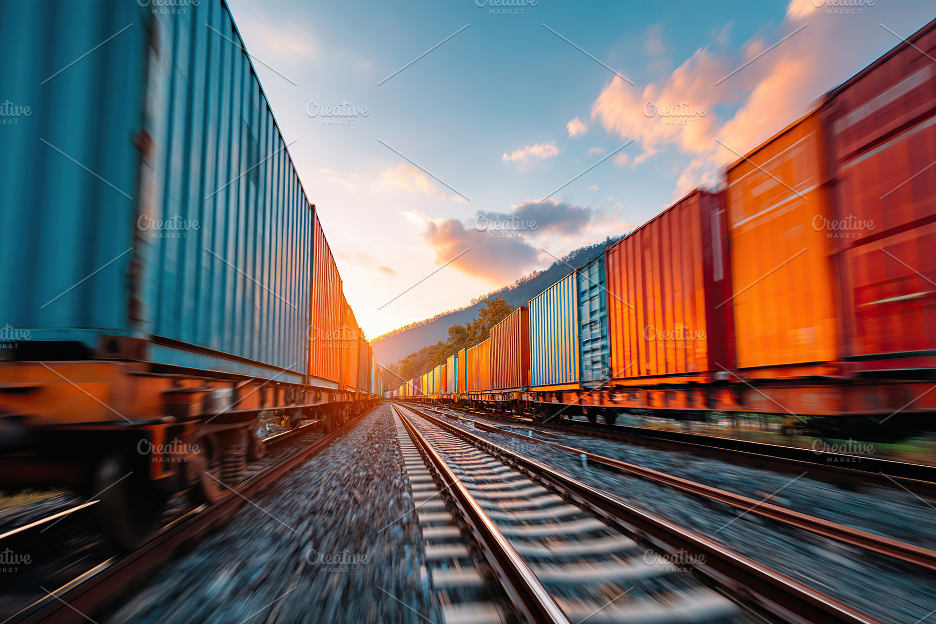 Container train travels along tracks during sunset near mountains, a Photo by AlyaAnd