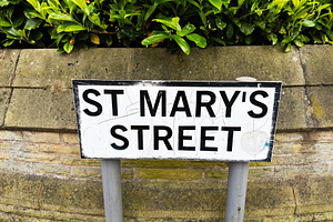 St Mary's Street sign on stone wall with green hedge in Manchest