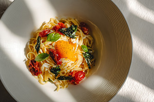 Fresh tagliatelle pasta with a rich egg yolk, sun dried tomatoes, a Photo by Studio ANNA