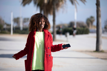Front view of a young beautiful curly african american woman jumping and dancin, a Person Photo by 2Design