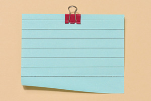 Blue sticky note secured with a red paper clip, centered on a be, a Beauty & Fashion Photo by ndanko