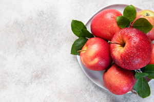 Fresh red apples with green leaves on white plate, a Food & Drink Photo by Olena Rudo