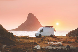 Van car camper at sunset ocean beach road trip in Norway caravan RV trailer tra