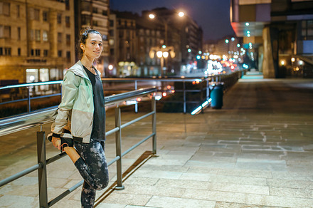 Woman runner stretching her legs next to banister before trainin