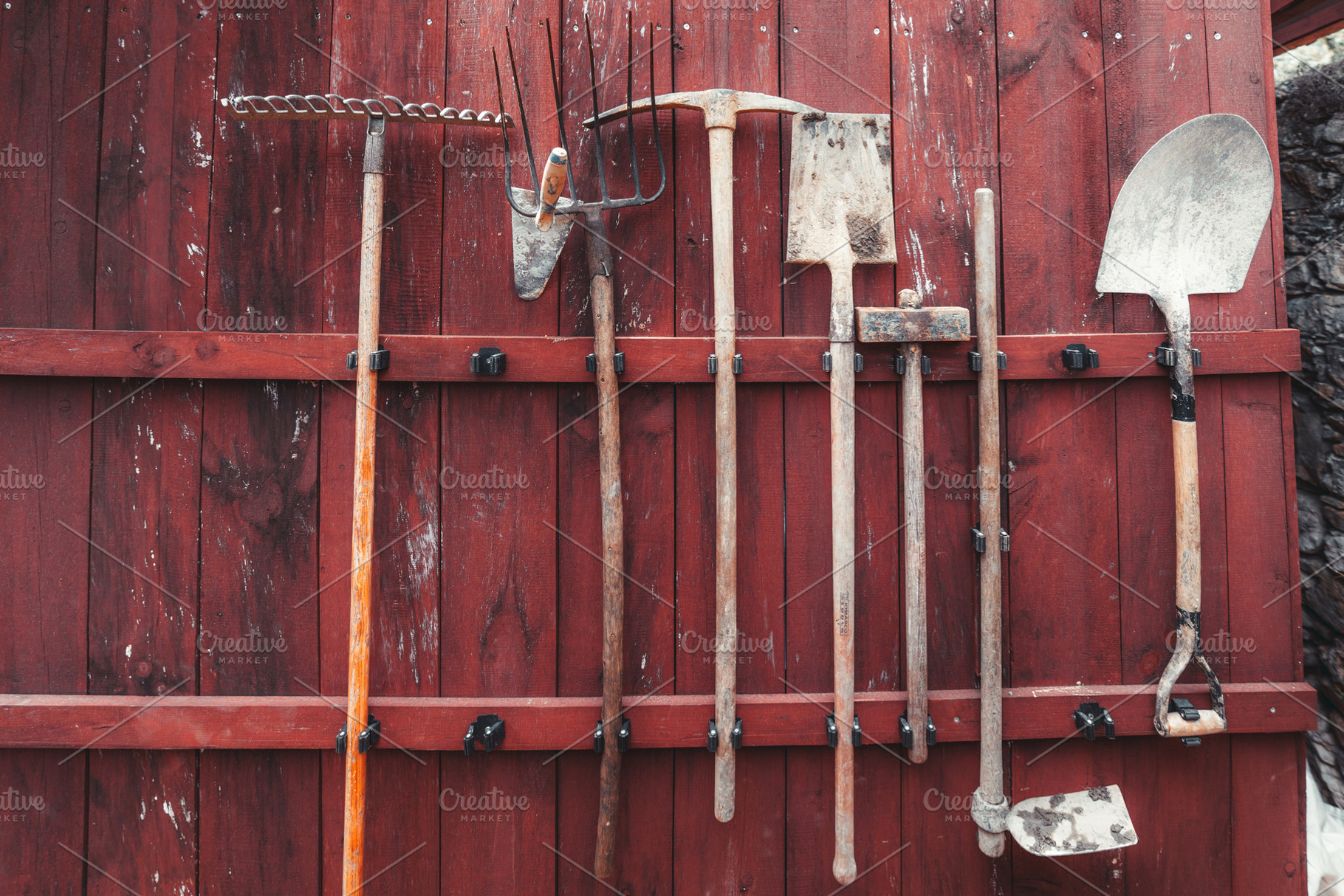 Garden tools on red wooden wall, an Industrial Photo by SkyNext